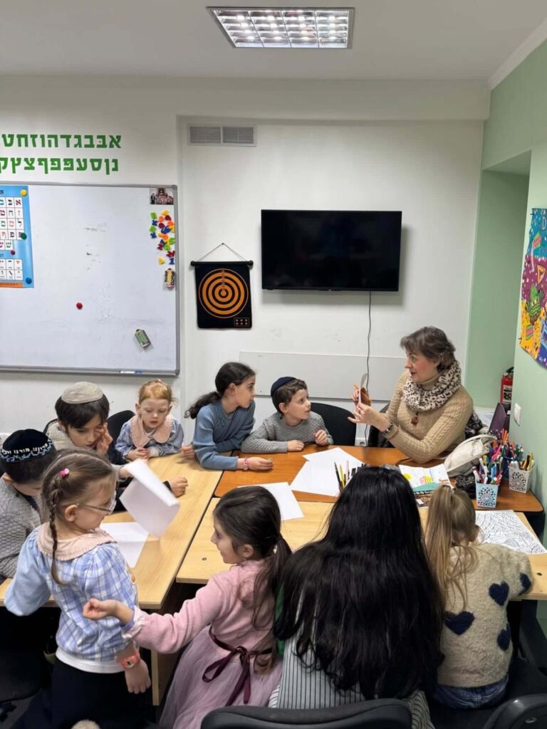Children smiling and playing games at the Moadon youth club in Chabad Kishinev